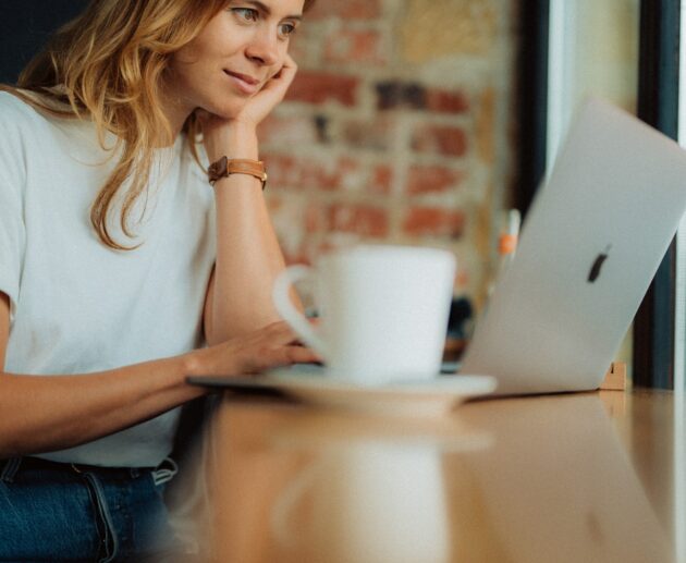 Online Workerin im Internet Cafe vor Laptop